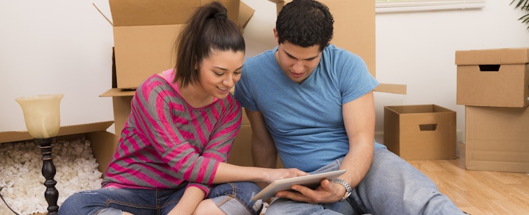 Young couple sitting on the floor in their new home.