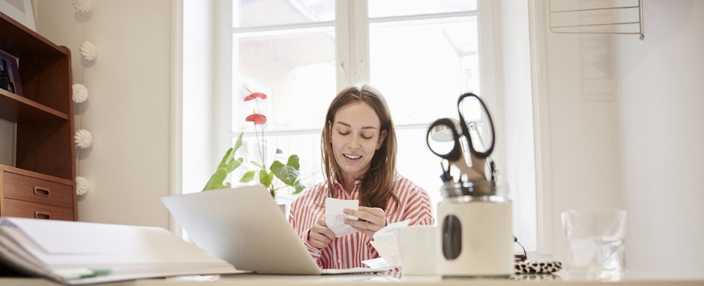 Woman examining receipts at home