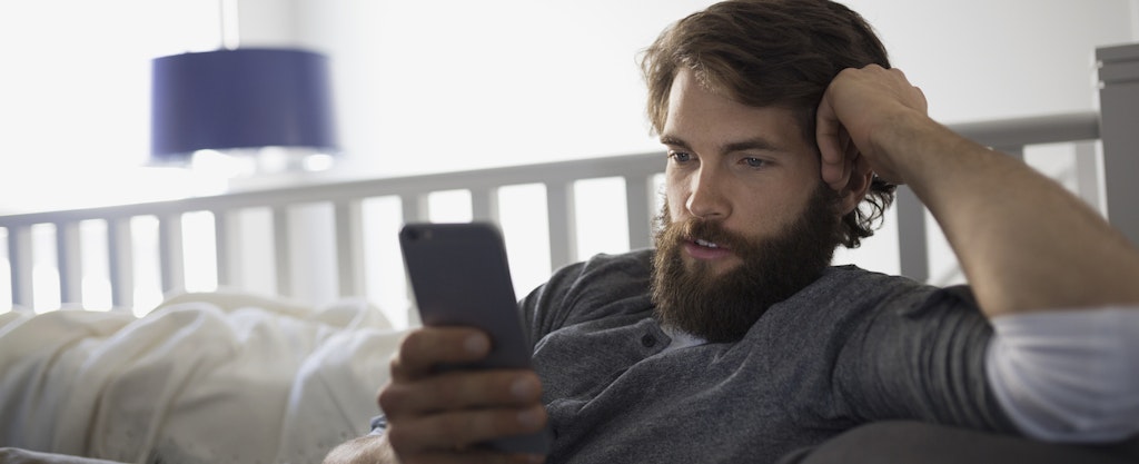 Man texting with cell phone on sofa