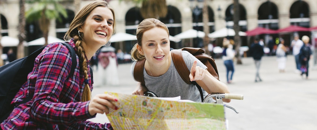 Two young female travelers reading a map