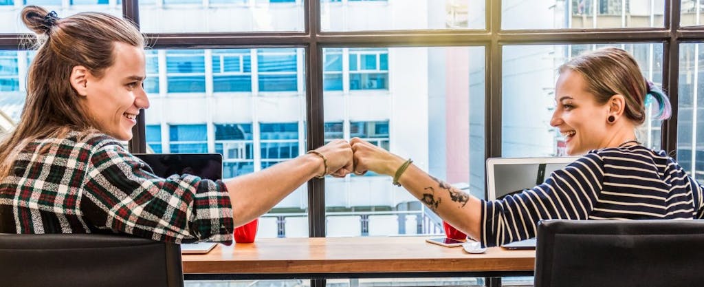 Young hipster couple fist bumping in victory after they learned about filing state taxes for free.