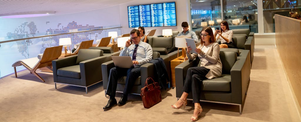 Traveling business people relaxing in a VIP lounge at the airport while waiting for their flight