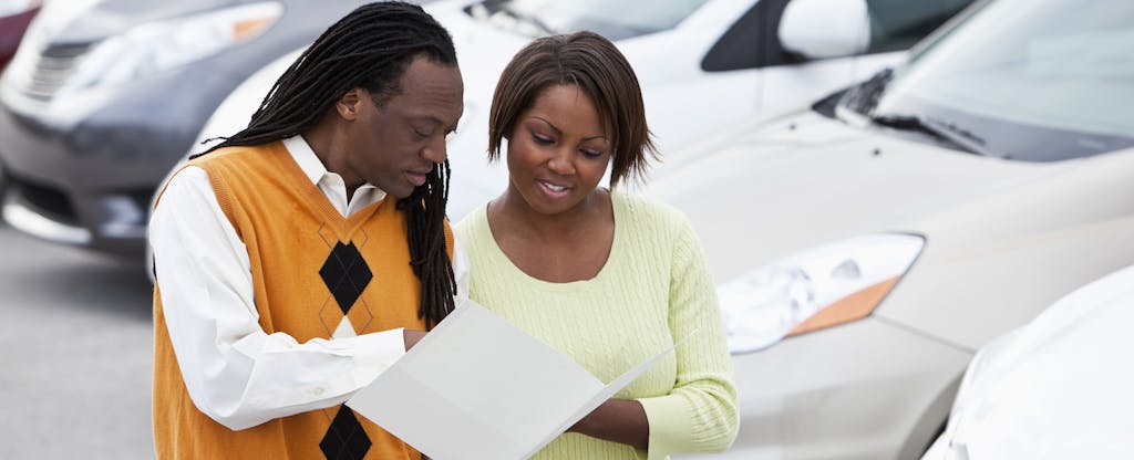 African American couple shopping for new car at dealership