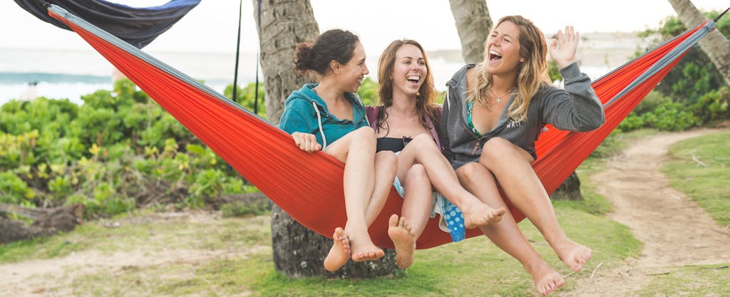 Three female friends in hammock together in tropical location