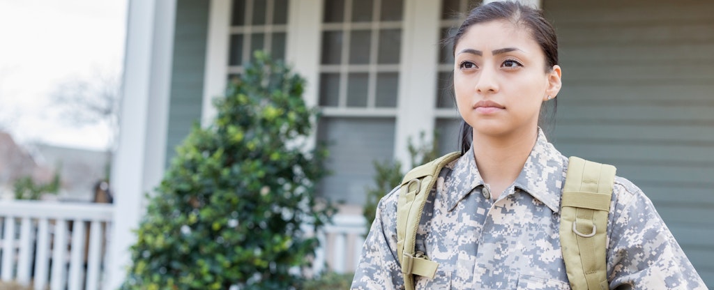 Female solider standing outside of her home and wondering if she can get a bad credit military loan