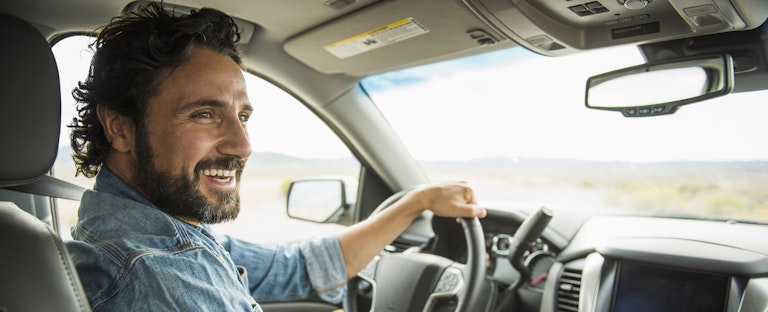 Man driving a car and smiling