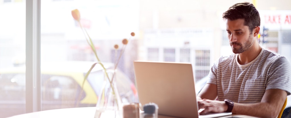 Man sitting in cafe and working on his laptop