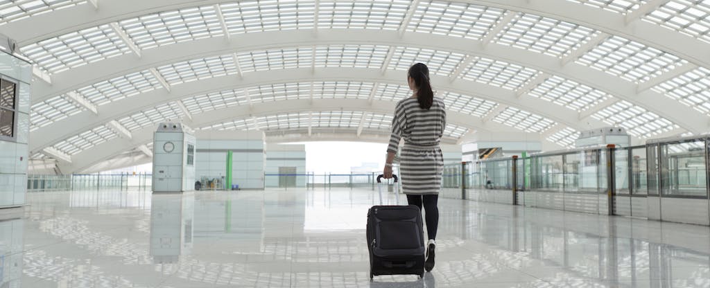 Business woman walking with suitcase in airport