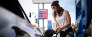 Young woman refueling car at the gas station.