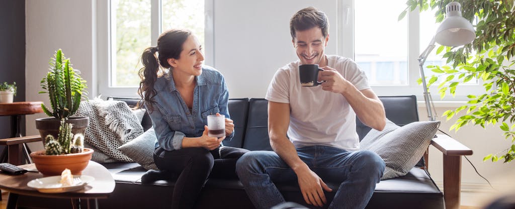 Couple sitting on the couch and drinking coffee together