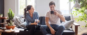 Couple sitting on the couch and drinking coffee together