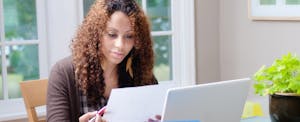 African American woman working at home with laptop