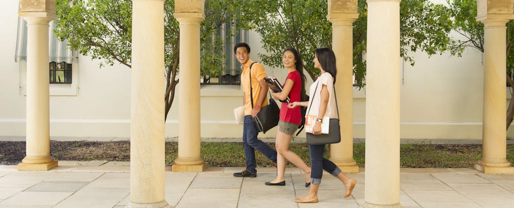 A group of 3 students walking together on campus