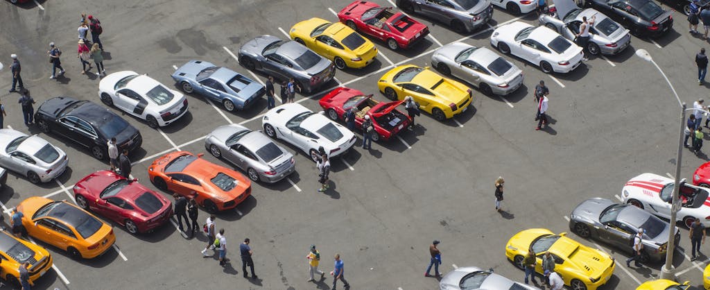 Aerial view of people in a parking lot buying cars at auction
