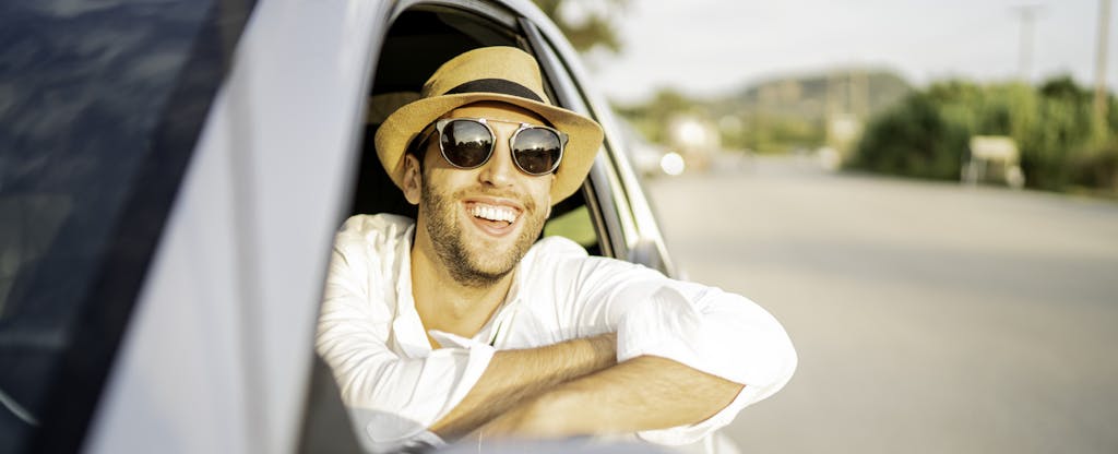 Man in a car leaning at window and smiling