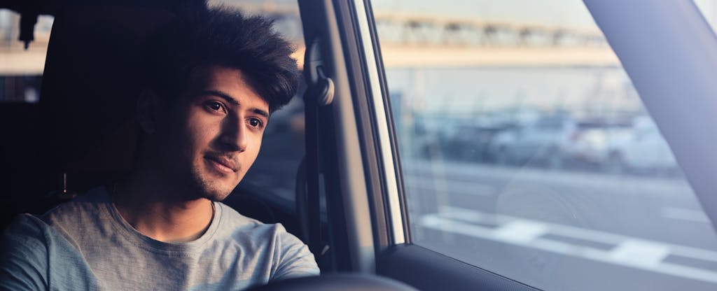 Man driving his car, a thoughtful expression on his face
