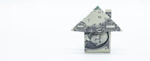 Image of a dollar bill that has been folded origami style into a small simple house with a chimney, symbolizing average american income