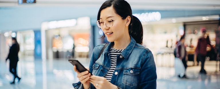 Young woman using smartphone in shopping mall