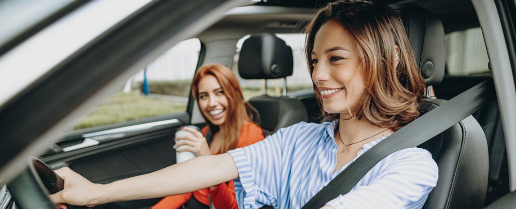 Two smiling women in car