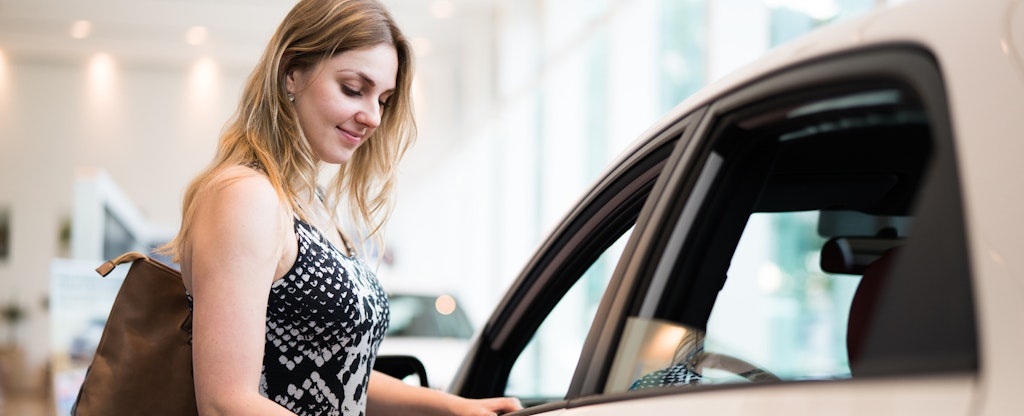 Young woman thinking about buying a rental car