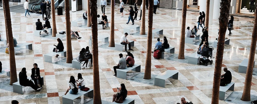 People sitting on benches in a mall lobby in New York