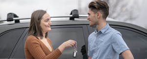 Young couple holding keys to their new car that they bought with Prestige Financial financing