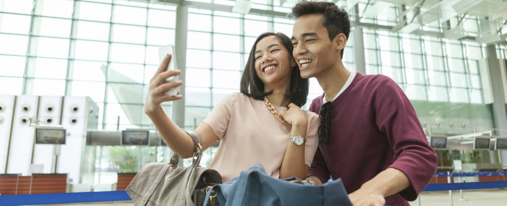 una pareja se toma una selfie juntos en el aeropuerto