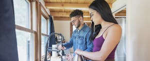 Young couple cooking in kitchen of their tiny home