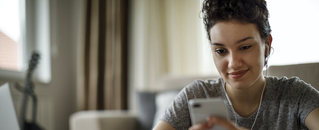 Closeup of young woman looking at her phone for different ways to save money