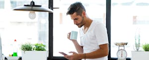 Man drinking coffee in kitchen, thinking about filing for florida unemployment benefits