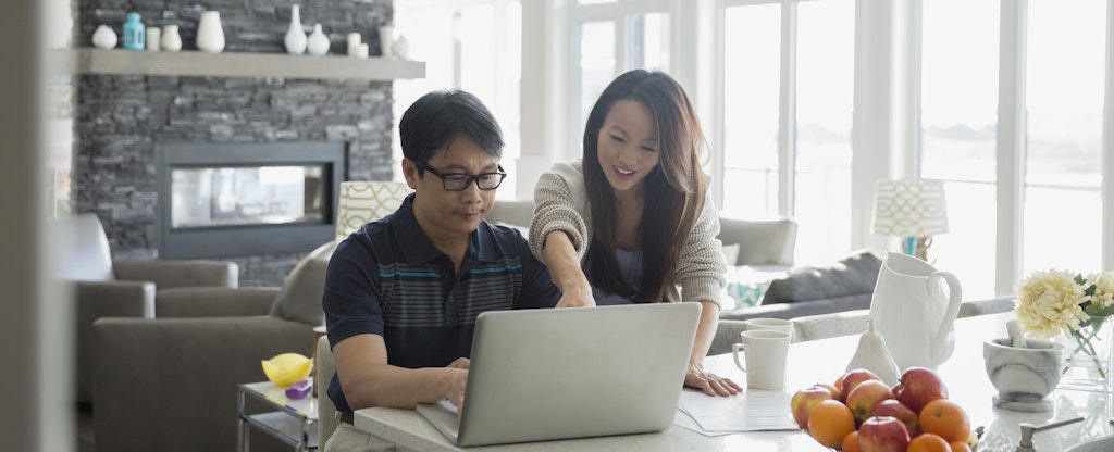 Couple at home learning what a credit bureau is on their laptop.