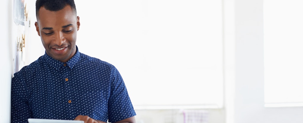 Man smiling and reading on his phone about what a fair credit score is