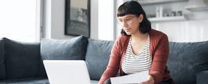 Woman sitting on sofa looking up payday loans in Georgia