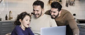 Happy fathers with daughter in their kitchen, looking up chase mortgage on their laptop