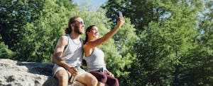 Couple on a hike, taking a selfie with their phone