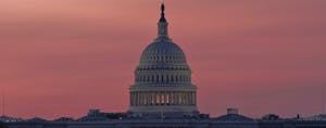 U.S. Capitol building at dawn, in front of an orange and rose-colored sky.