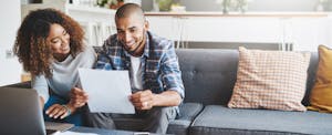 Young couple at home, using laptop to apply for a consumer direct mortgage