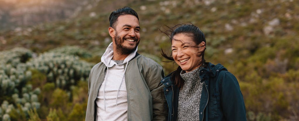 couple smiling with countryside in background