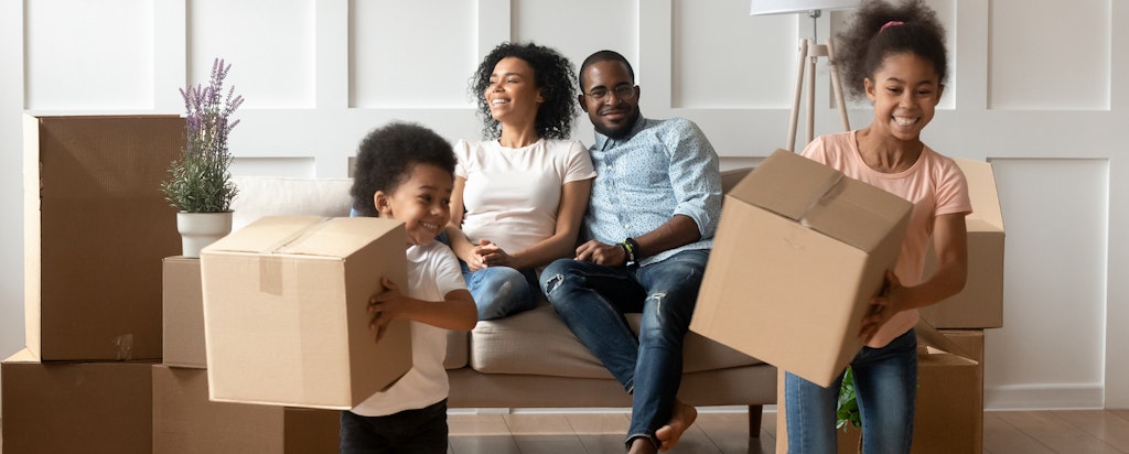 Happy parents and kids in home with moving boxes