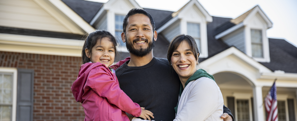 Smiling family in front of their brand new home