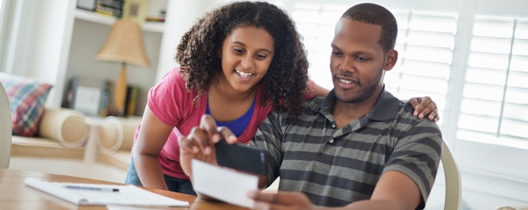 Father with daughter looking over finances and smiling