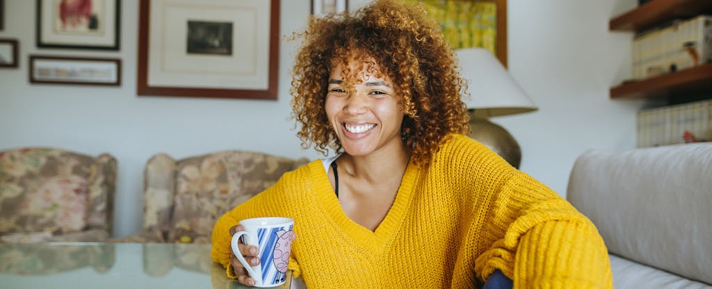 Woman sitting at her table at home, smiling