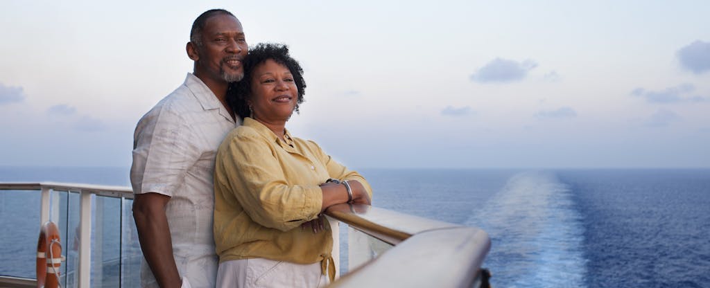 Man and woman standing together on deck a cruise ship, enjoying the view