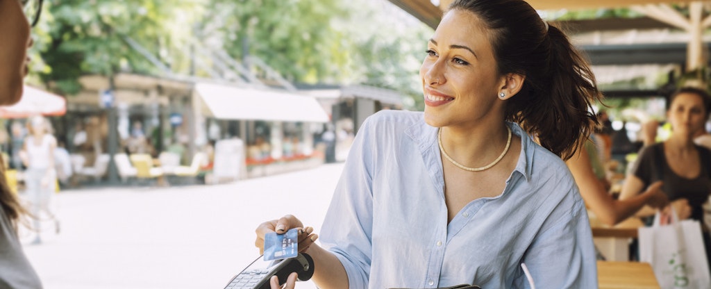 A woman smiles while using her us bank altitude connect at a restaruant.