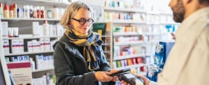 Woman using Samsung pay to check out at a pharmacy