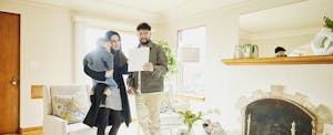 Young couple in their new, bright and sunny home, with their mortgage gift letter in hand
