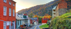 A small town main street in West Virginia with a hillside and the setting sun in the background.