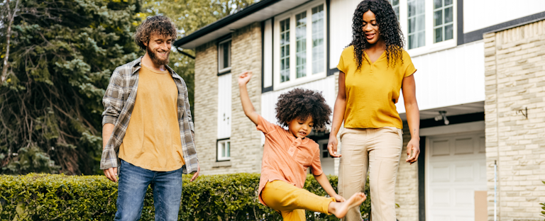 Young family in the front yard of their new home