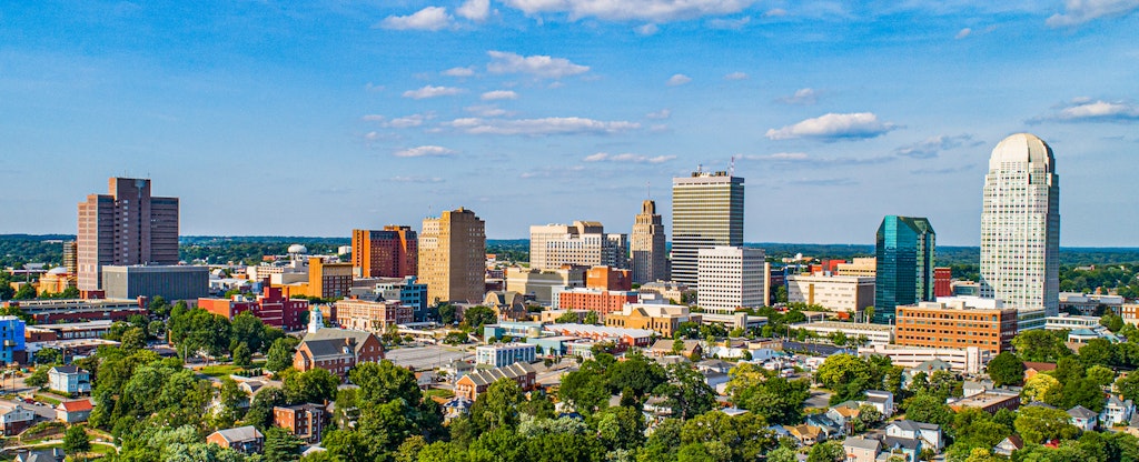 The downtown Winston-Salem, North Carolina, skyline under a cloudy blue sky.
