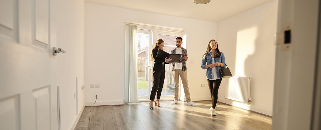 Real estate agent showing a young couple around a new house